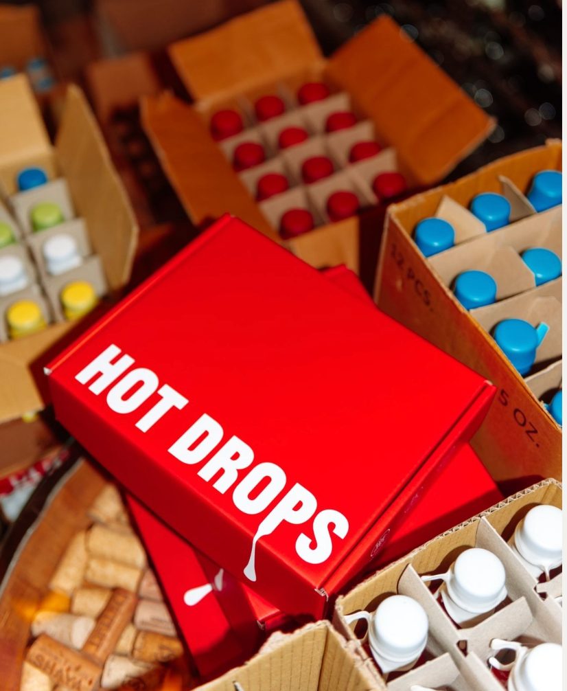 A closed mailer on the fulfilment table among case boxes of bottles