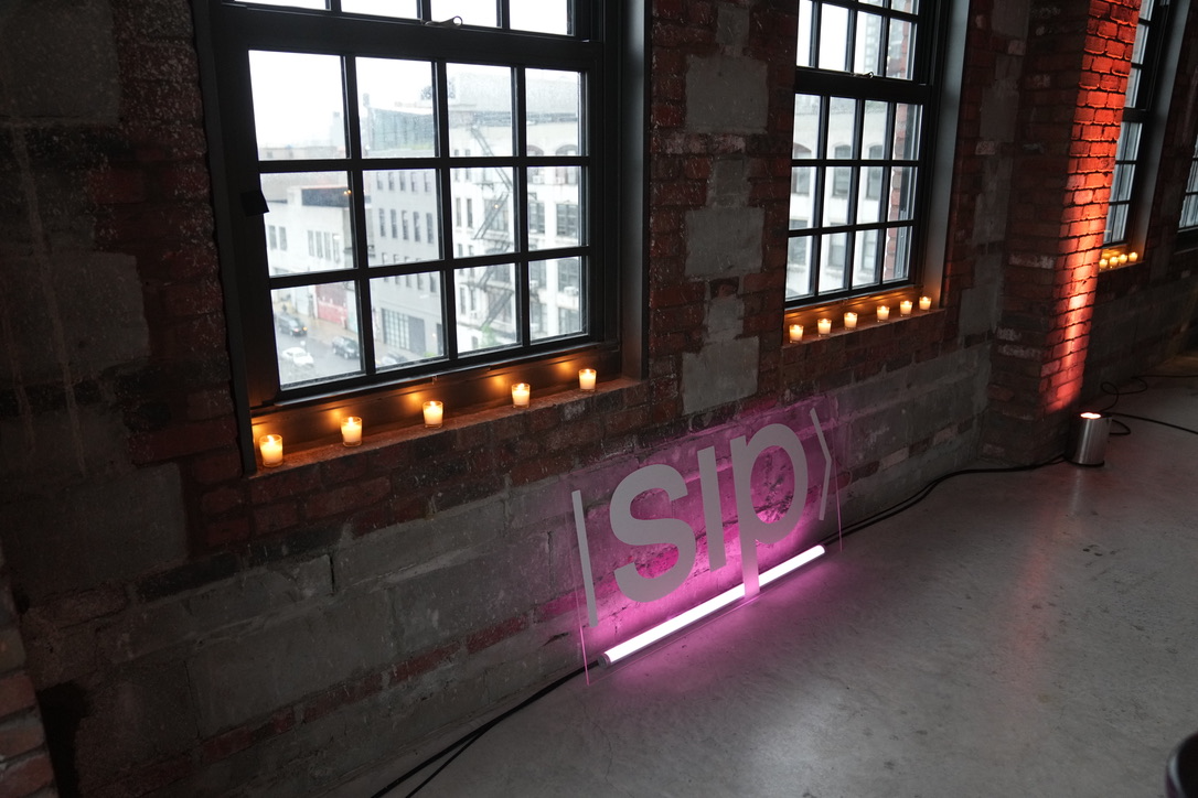 Pink neon mark against brick